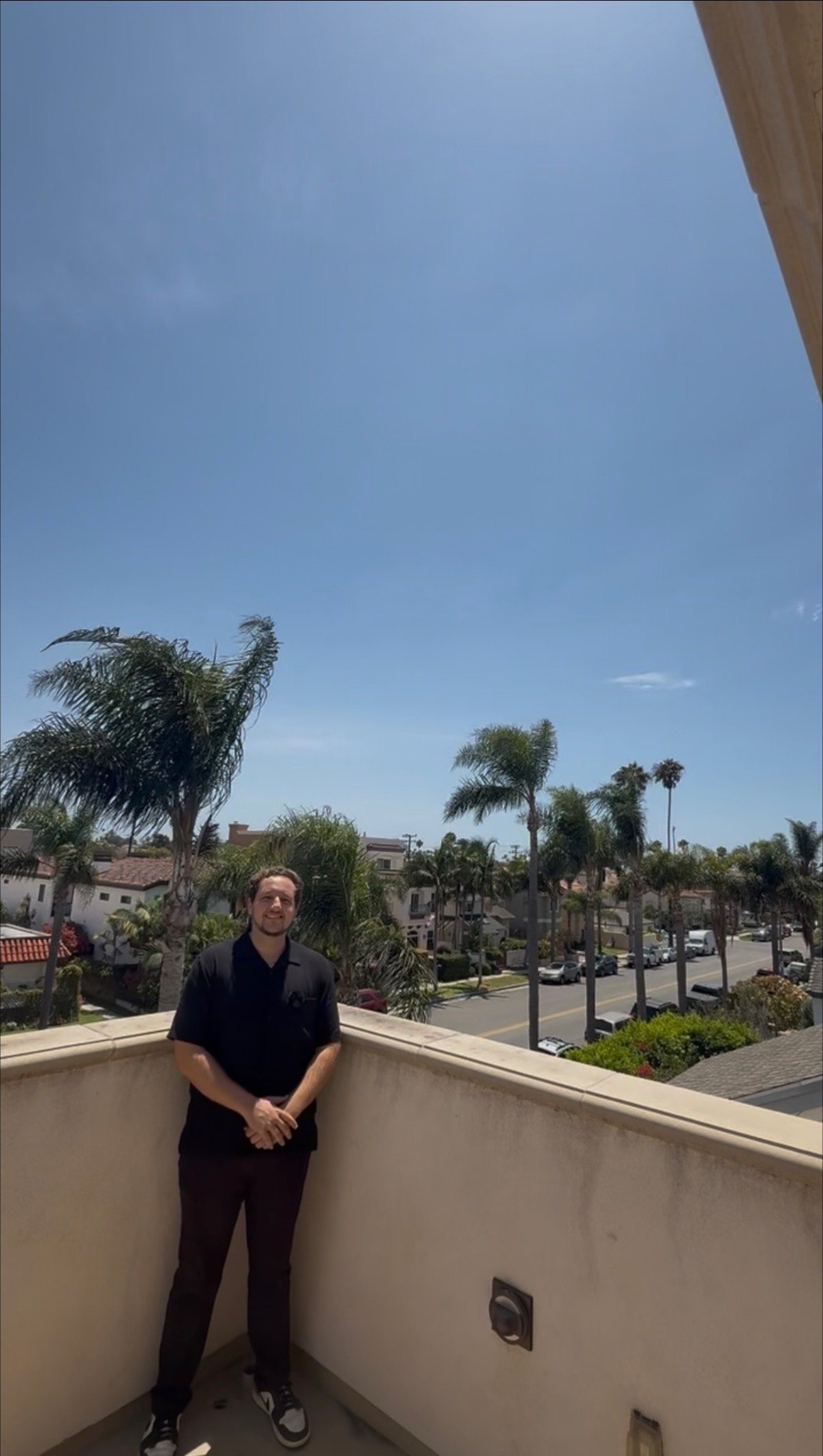 Daniel Cherney on a rooftop overlooking a palm-lined Orange County street